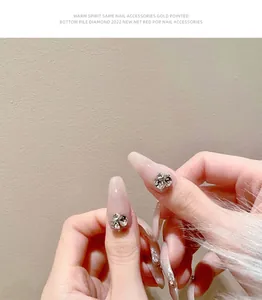 Vue macro détaillée exquise de strass fleurs en cristal 3D sur des ongles roses manucurés