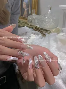 Detailed view of luxury nail art jewelry with pearl bow pendants and rhinestone accents