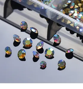 Gros plan détaillé de strass irisés à dos pointu pour nail art avec boîte de rangement.