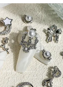 Detailed view of silver nail art charms featuring luxury pearls and sparkling zircon