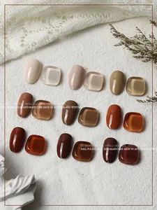 Detail of caramel and cocoa brown gel nail polish color palette on textured white fabric