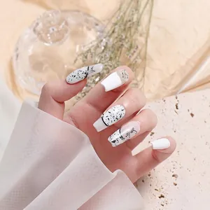 Stylish nail art showing black and white quail egg shell spotted pattern on long nails