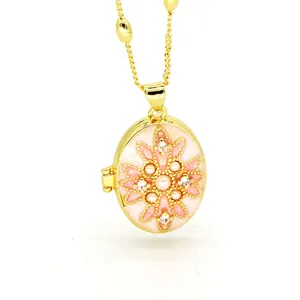 Detail view of the intricate floral pearl and crystal design on a pink enamel locket.