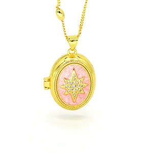 Macro view showing a gold-plated oval locket necklace with pink enamel and star charm.