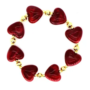 Close-up of a French style resin red heart and gold beaded elastic jewelry piece