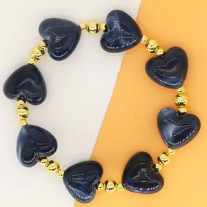Detailed view of navy blue heart resin beads and gold spacer beads on a bracelet
