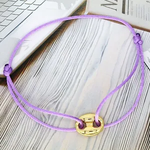 Detailed view of the purple adjustable rope bracelet featuring a gold pig nose charm