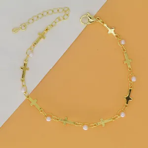 Elegante gouden armband met fijne kruisbedeltjes en witte parelaccenten voor dames