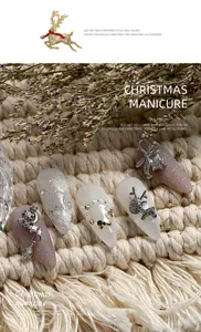 Close-up detail of silver Christmas nail art charms with elk and snowflake zircon accents