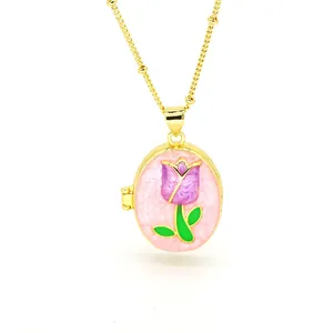 Close-up of golden oval photo locket necklace with purple tulip enamel detail