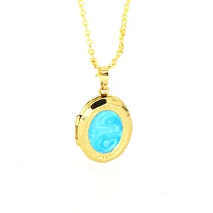 Elegant gold-toned oval locket necklace featuring a blue marbled enamel pendant detail