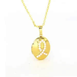 Close-up detail of a vintage gold oval locket necklace with a delicate pearl ribbon inlay