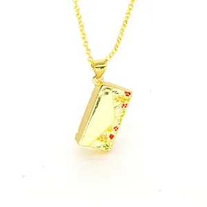 Detailed macro view of a gold envelope pendant with vibrant floral enamel patterns
