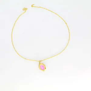Detailed view of a gold oval locket pendant necklace featuring a pink enamel center