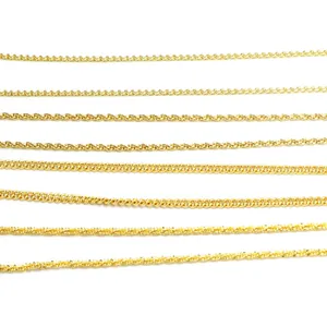 Detailed macro view of various gold-plated chain styles including box and snake chains.