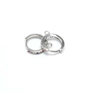 Détail de créoles argentées pour DIY avec petites boucles et pierres colorées.