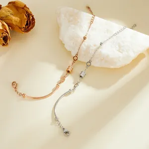 Detailed view of rose gold and silver stainless steel cylinder charm chain bracelets