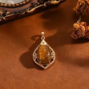 Vintage geometrische koperen hanger met een ovale bruine kattenoogsteen in goud.