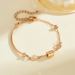 Detail of rose gold titanium steel bracelet with geometric cylindrical charm and chain links