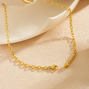 Macro detailopname van vergulde rvs ketting met karabijnsluiting en een klein metalen bolletje