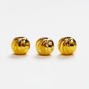 Macro view of three 18k gold filled beads with twisted grooved texture for DIY jewelry.