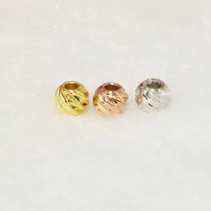 Close-up of three 11-cut textured spacer beads in gold, rose gold, and silver colors.