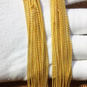 Macro view of gold-plated curb chain links showing high-shine texture and finish
