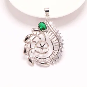 Detailansicht eines silbernen Muschel-Anhängers mit grünem Stein für DIY-Schmuck