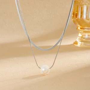 Gros plan d'un élégant collier à double épaisseur en acier avec pendentif perle