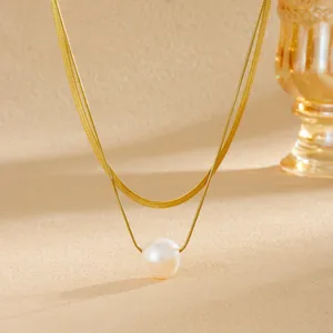 Détail d'un élégant collier double épaisseur en or avec un pendentif en perle fine