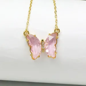 Detailansicht eines süßen rosa Kristall-Schmetterlingsanhängers an einer goldenen Kette