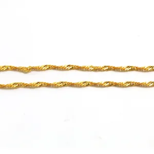 Close-up detail of golden water wave necklace chain with intricate spiral links
