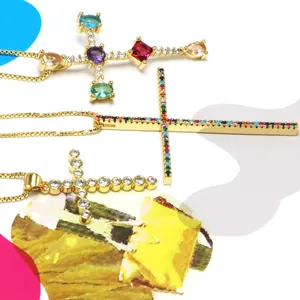 Detailed view of three gold-plated cross necklaces with colorful micro-pave zircons.
