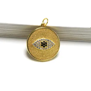 Close-up detail of a gold-plated evil eye pendant with sparkling crystal inlay for jewelry
