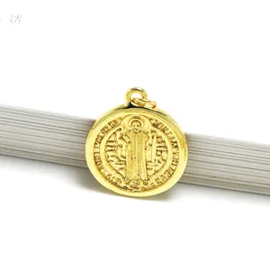 Detailed macro shot of a gold-plated St. Benedict religious medal pendant