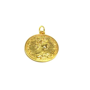 Detailed macro view of a gold-colored coin pendant featuring an embossed classical portrait