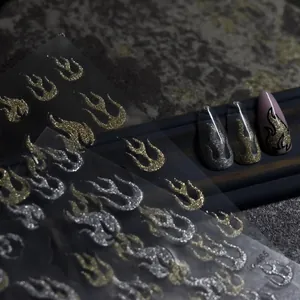 Detail of 3D glitter flame nail stickers in metallic gold and silver textures
