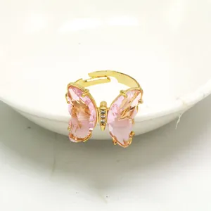 Nahaufnahme eines goldenen Schmetterlingsrings mit rosa Kristallflügeln und Glanz