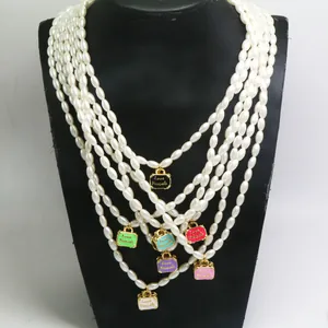 Detail of a multi-strand faux pearl necklace featuring colorful enamel bag charms