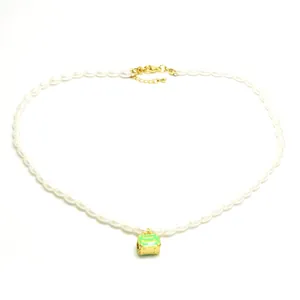 Detailed view of vintage faux pearl necklace with green enamel handbag pendant charm