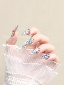 Macro view of luxurious AB Aurora rhinestones on long nails with silver base super flash