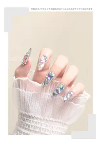 Detailed close-up of iridescent AB rhinestones with silver base on manicured nails