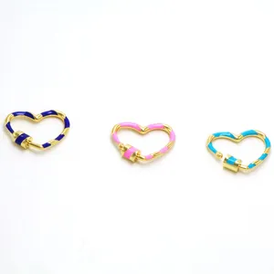 Détail de trois fermoirs à vis en cœur émaillé en bleu, rose et bleu clair pour bijoux DIY