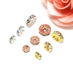 Nahaufnahme funkelnder Strass-Rondelle-Abstandsperlen in Gold- und Silberplattierung.
