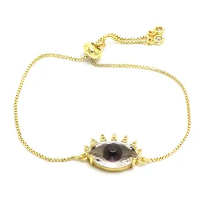 Primer plano de pulsera dorada con ojo turco de cristal y detalles de diamantes de imitación.