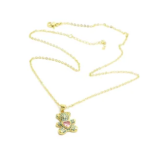Close-up of golden bear pendant necklace with blue and pink heart zircon stones