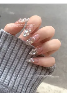 Primo piano di lussuose decorazioni per unghie con perle e diamanti a fondo piatto.