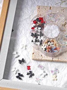 Detailopname van 7-vaks nail art kit met 3D-strikjes, vlinders en witte parels