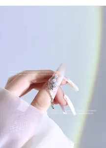 Detail of silver star and moon nail chain with pearls and zircon on long nails.