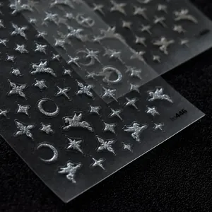 Detailed close-up showing silver glittery nail stickers with star and moon patterns
